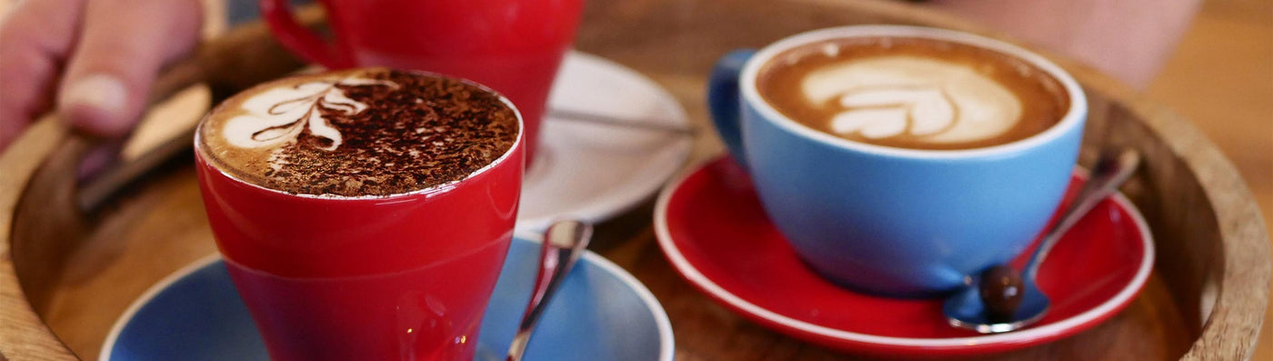 Cappuccino mit Latte Art und Schokolade auf dem Tisch