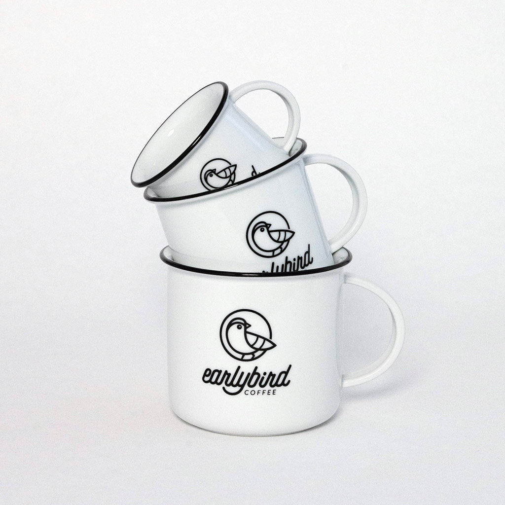 earlybird Espressotasse, Kaffeetasse und Kaffeebecher aus weißem Keramik mit schwarzem Tassenrand und earlybird coffee Logo ineinander gestapelt